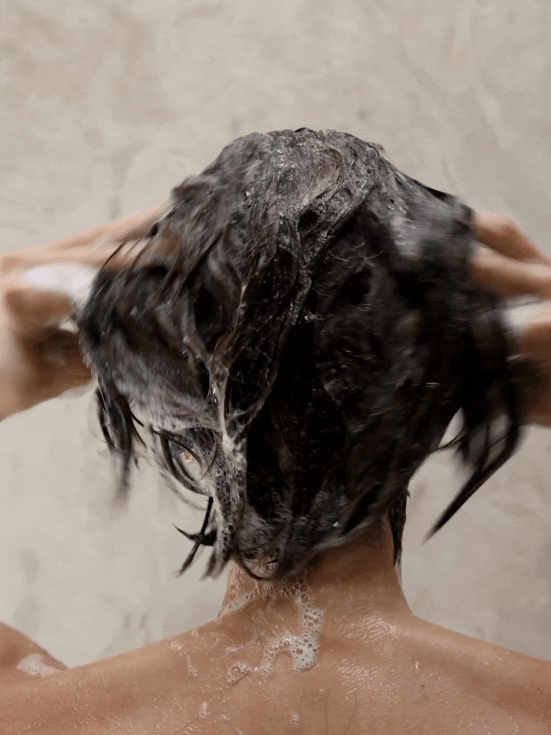 Woman shampooing and lathering her hair with Rahua Aloe Vera Shampoo