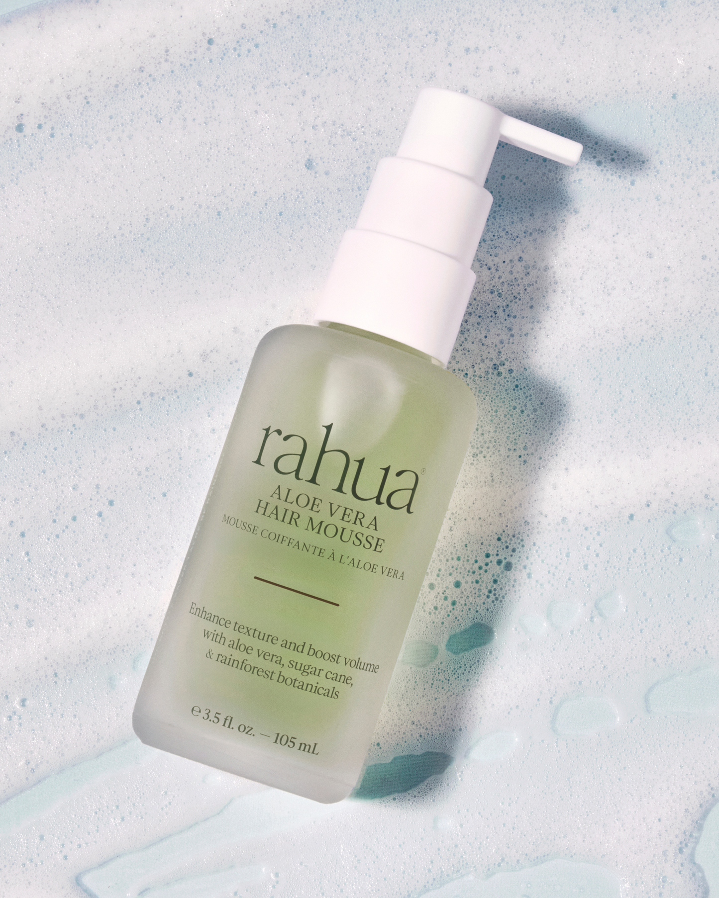 Bottle of Rahua Aloe Vera Hair Mousse on a textured blue background
