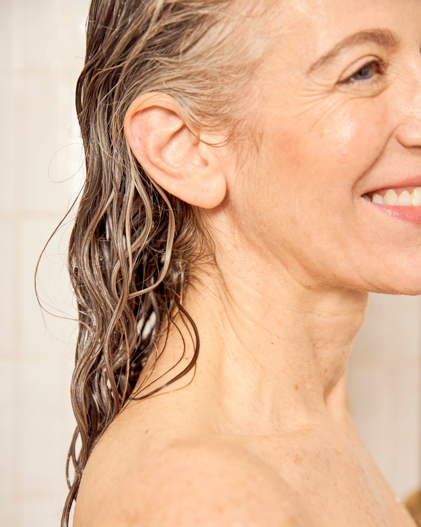 model with wet hair smiling against a neutral background|variant:93-oz