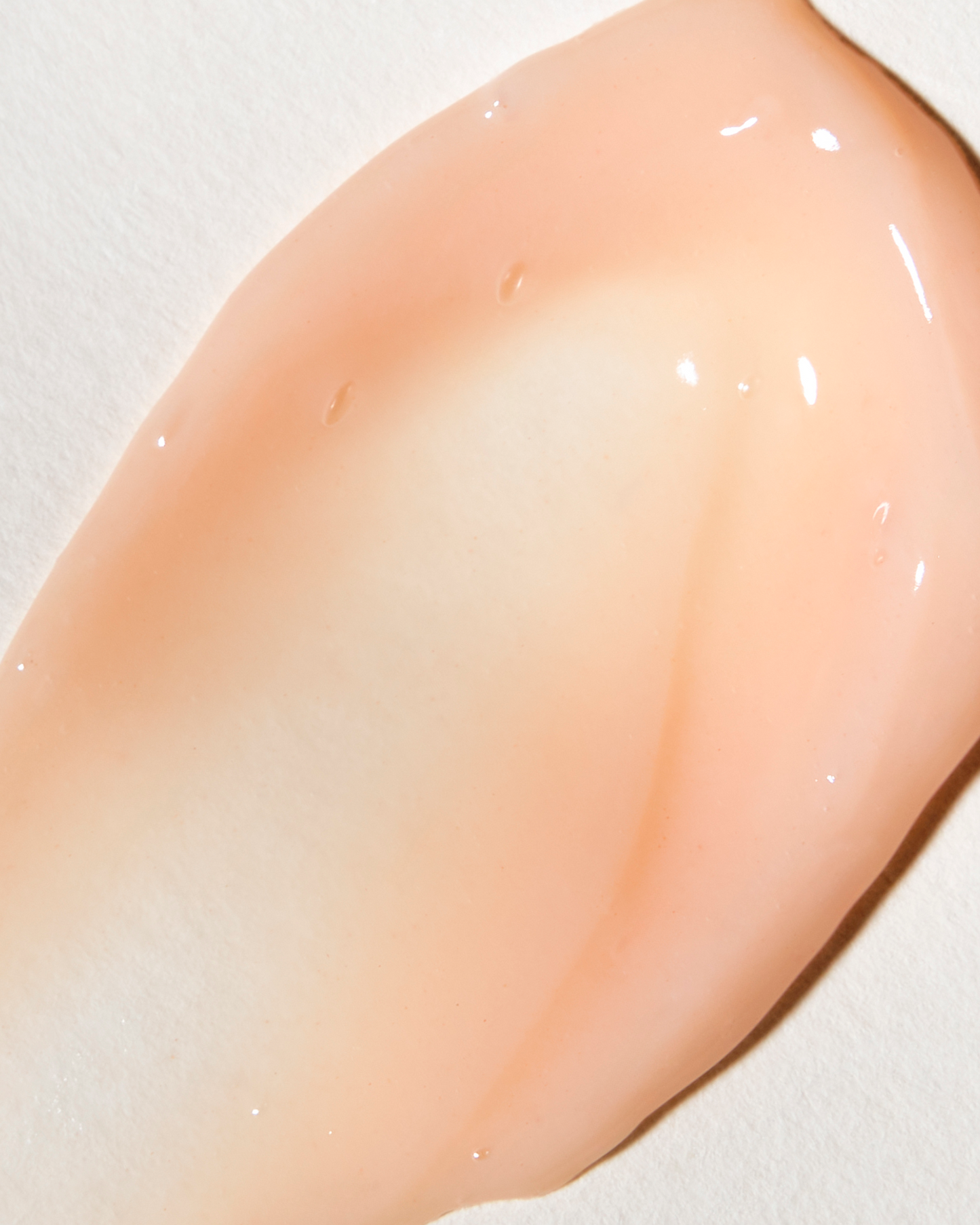 Close-up of a smooth, pinkish-beige surface with a white background