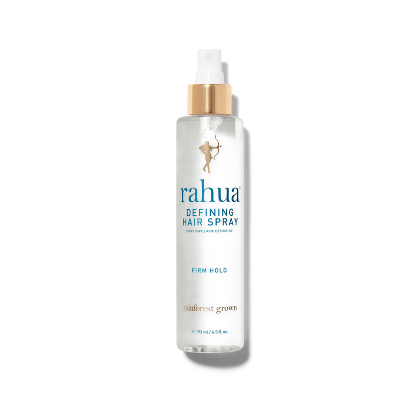 A bottle of Rahua defining hair spray with a white pump and transparent bottle, displaying the light blue liquid inside.