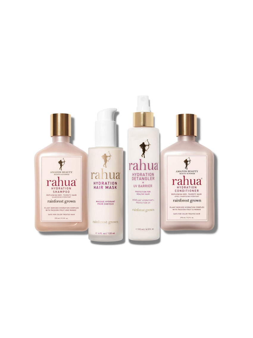 A set of four Rahua hair care products, including a hair mask, detangler, shampoo, and conditioner, each in a tall, slender white bottle with gold-colored caps. The products are labeled with the brand name 'Rahua' and the words 'Hydration Heroes'.