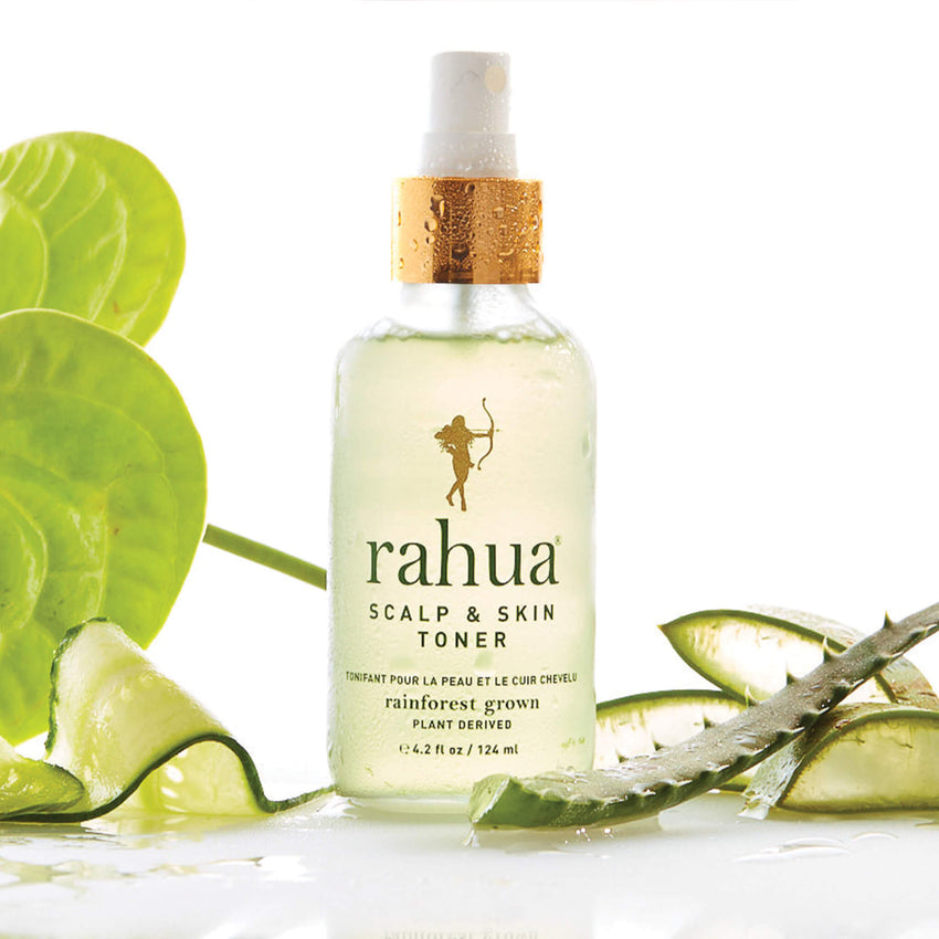 glass spray bottle with gold collar and green text rahua scalp and skin toner on a plain white background with slices of cucumber and aloe vera|variant:42-oz