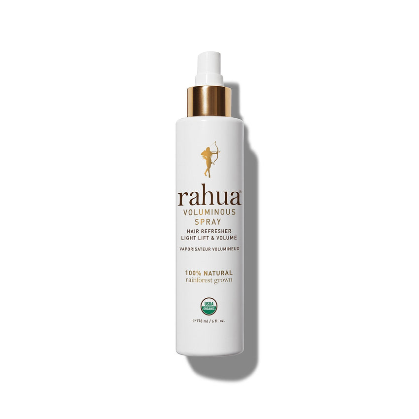 A bottle of Rahua Voluminous Spray, a hair refreshing spray with a white and orange design, indicating it is a beauty product.