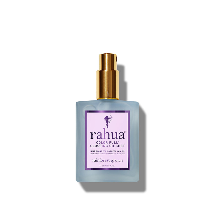 A bottle of Rahua Color Full Glossing Oil Mist with a white label and blue liquid visible inside. The bottle is designed with a gold-colored cap and a clear glass body.